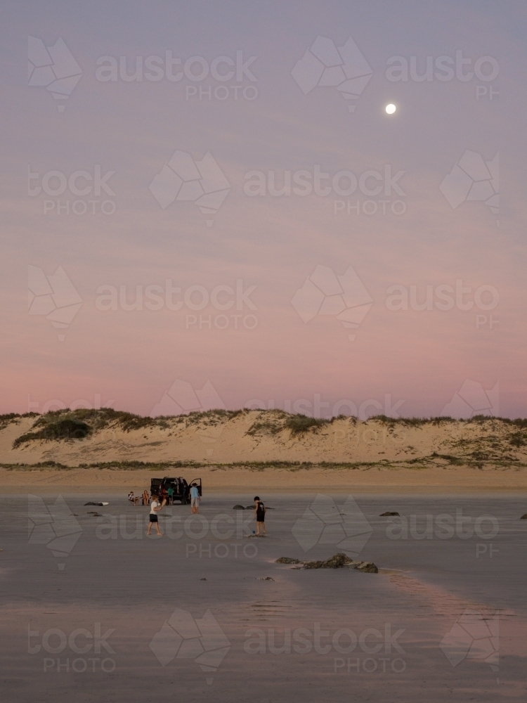 4WD on Cable Beach with Moon in Background - Australian Stock Image