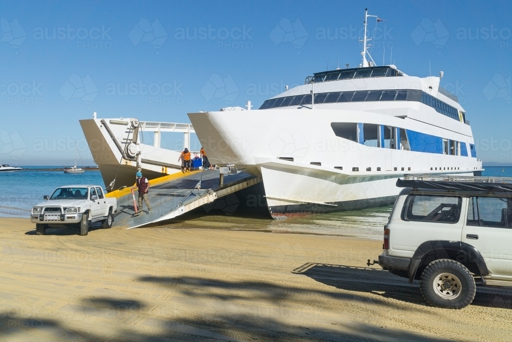 4WD's driving off a car ferry onto a beach - Australian Stock Image