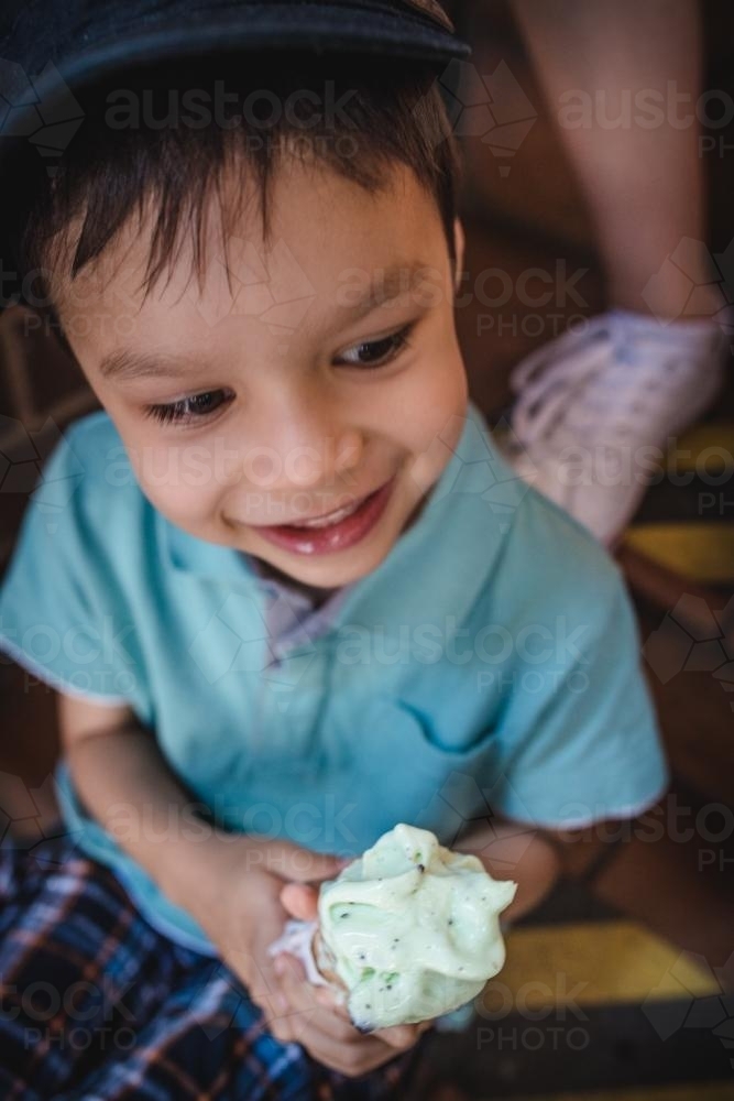 5 year old mixed race boy eating ice-cream on a warm summer day - Australian Stock Image