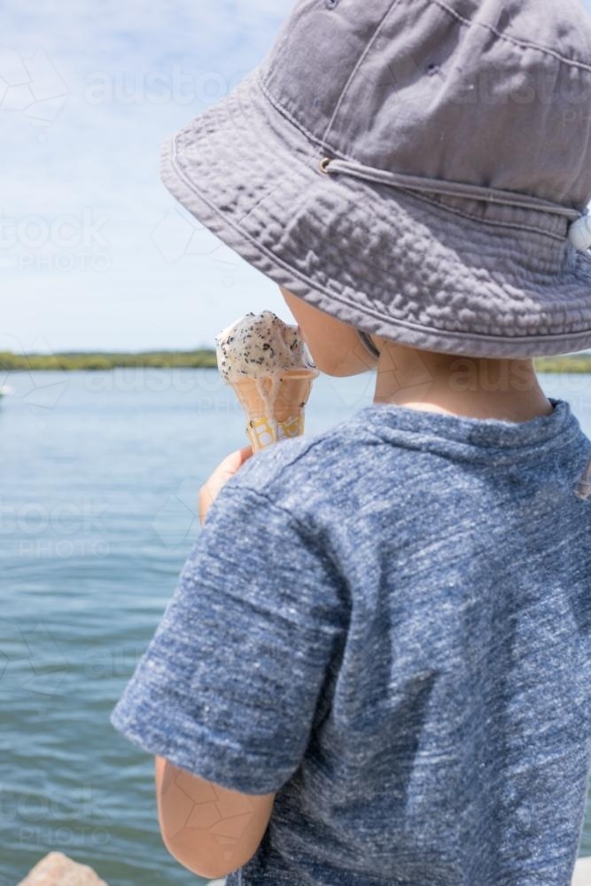 5 year old mixed race boy eating ice-cream on a warm summer day - Australian Stock Image