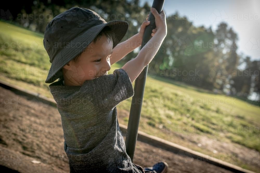 5 year old mixed race boy plays outdoors in a playground - Australian Stock Image