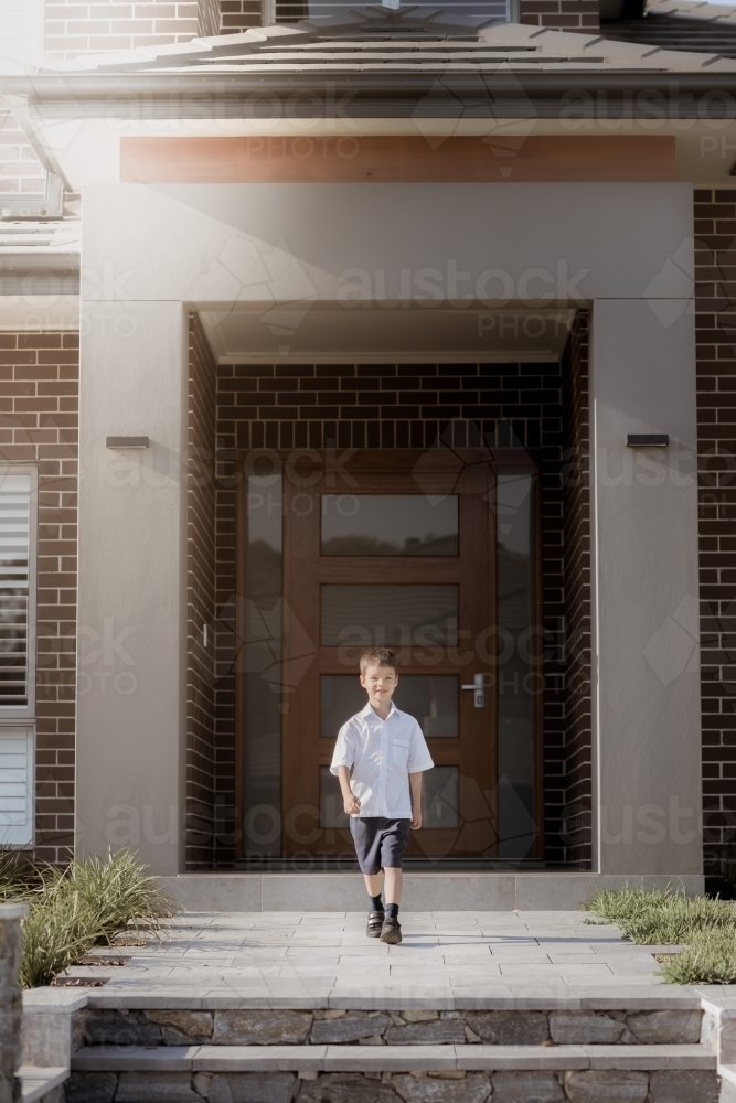 6 year old mixed race boy leaves home for his first day of school - Australian Stock Image