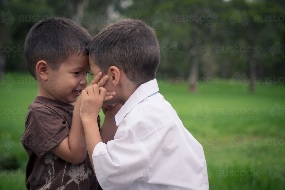 6 year old mixed race boy plays with his brother before leaving on his first day of school - Australian Stock Image