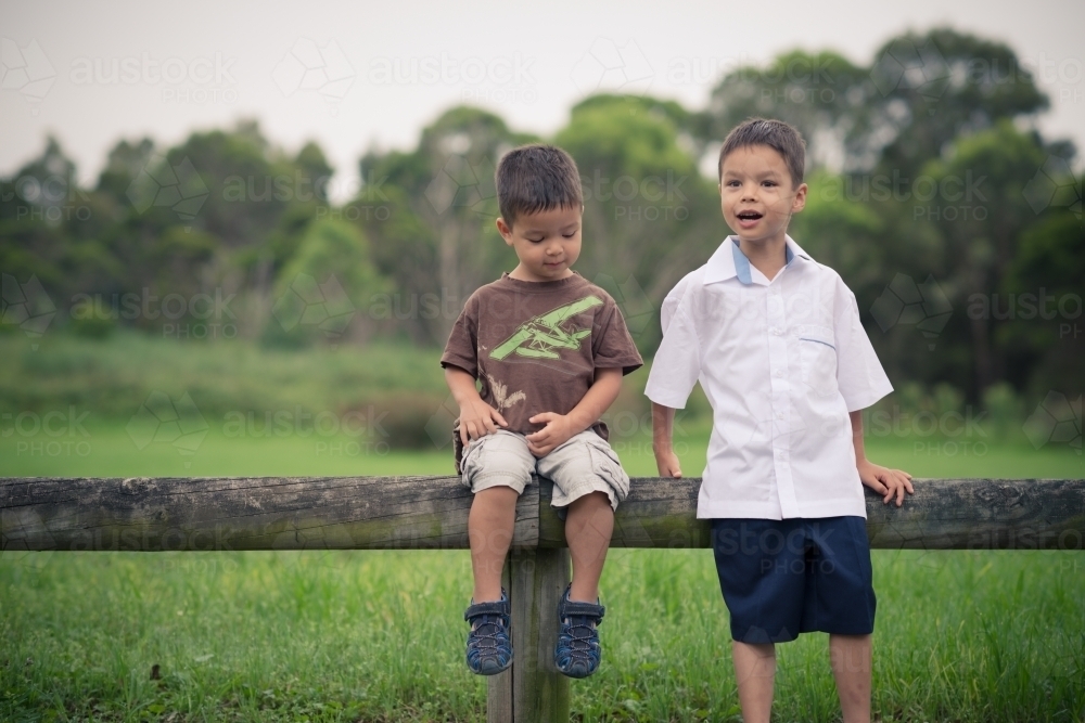 6 year old mixed race boy plays with his brother before leaving on his first day of school - Australian Stock Image