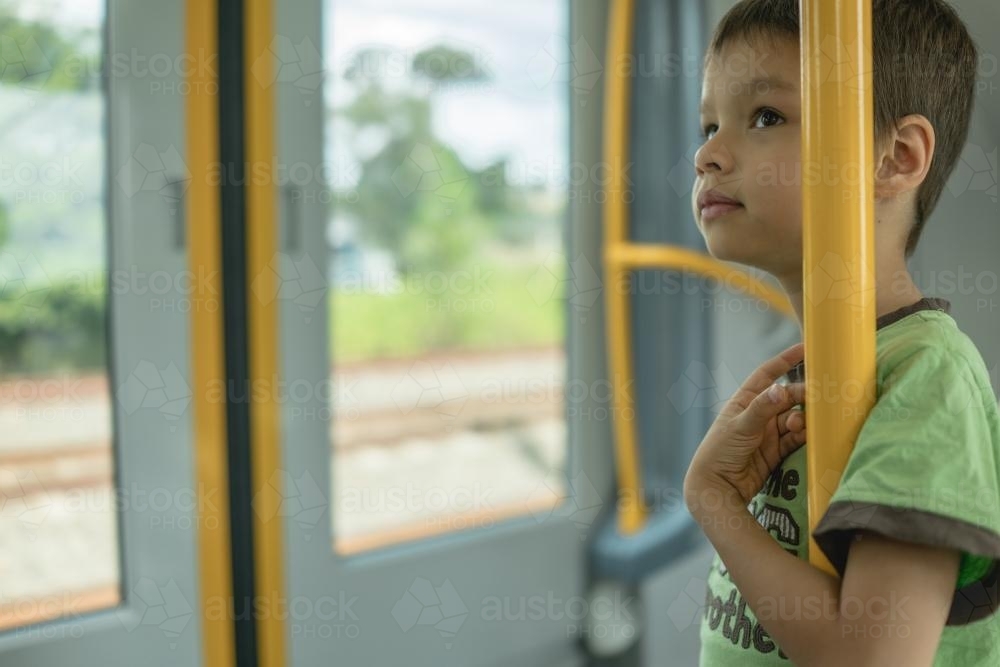 6 year old mixed race boy rides on a Sydney city train - Australian Stock Image