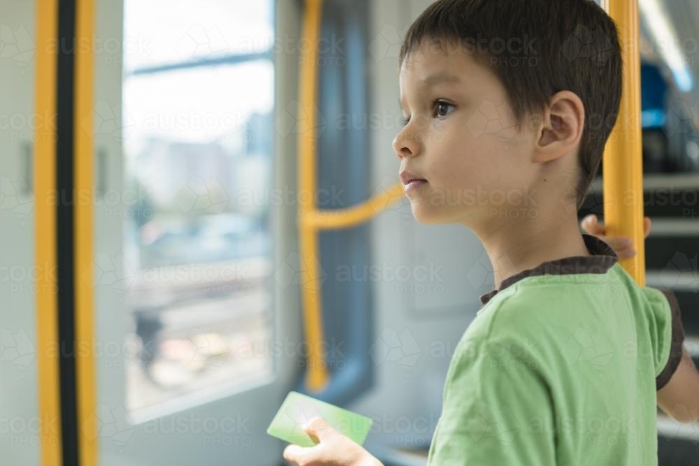 6 year old mixed race boy rides on a Sydney city train - Australian Stock Image