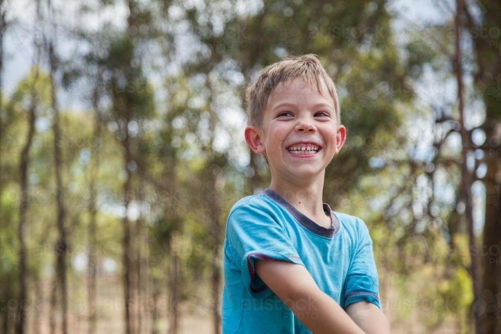 Image of 7 year old boy with a cheeky grin laughing Image of 7 year old boy with a cheeky grin laughing