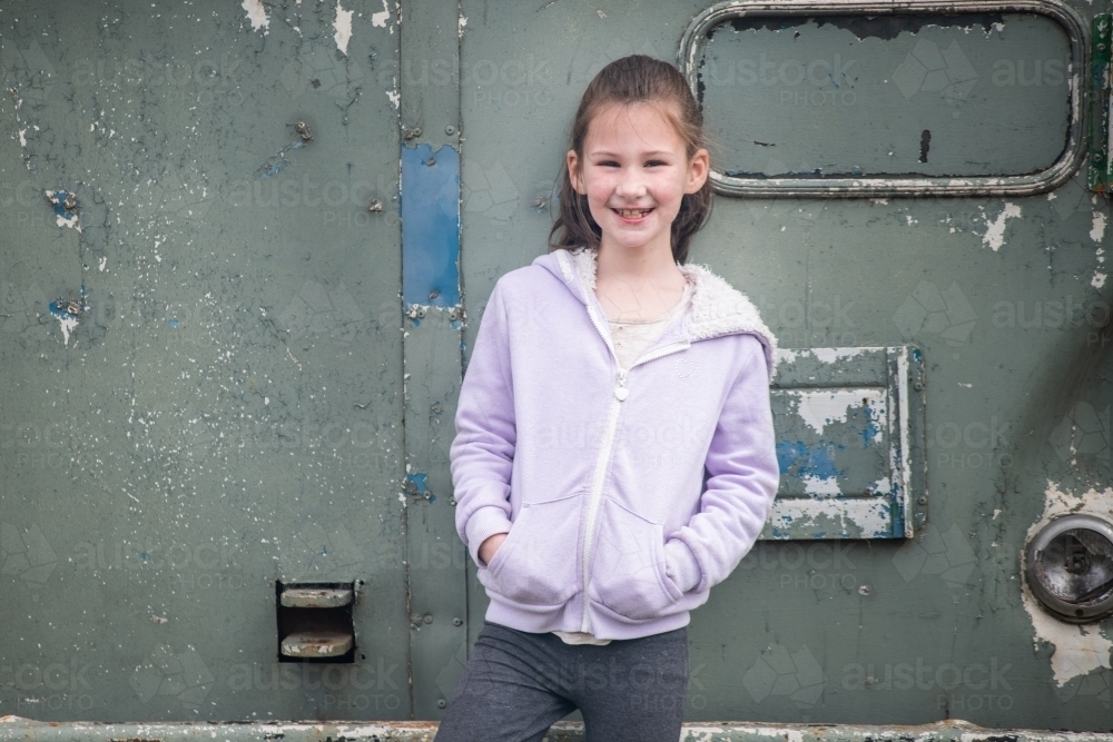8 year old girl posing in front of an old bus. - Australian Stock Image