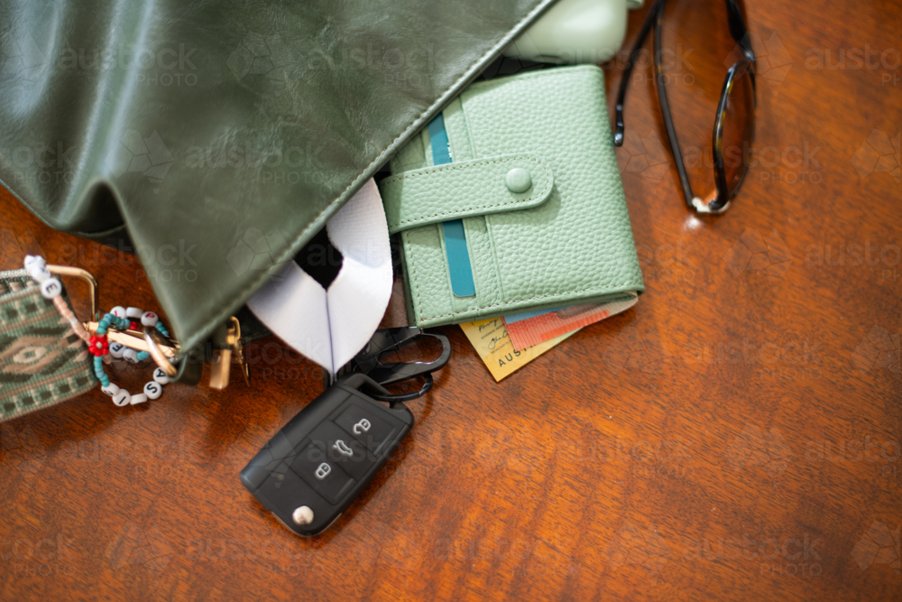 a bag with a wallet with cash, sunglasses and keys - Australian Stock Image