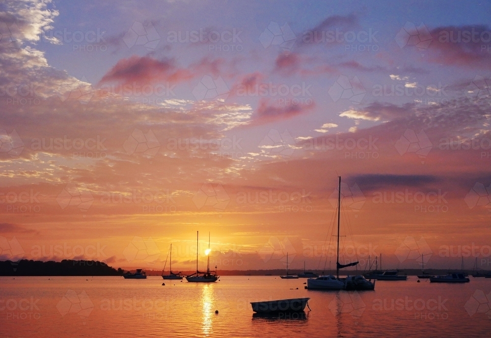 A beautiful sunrise over the boats moored in Moreton bay - Australian Stock Image