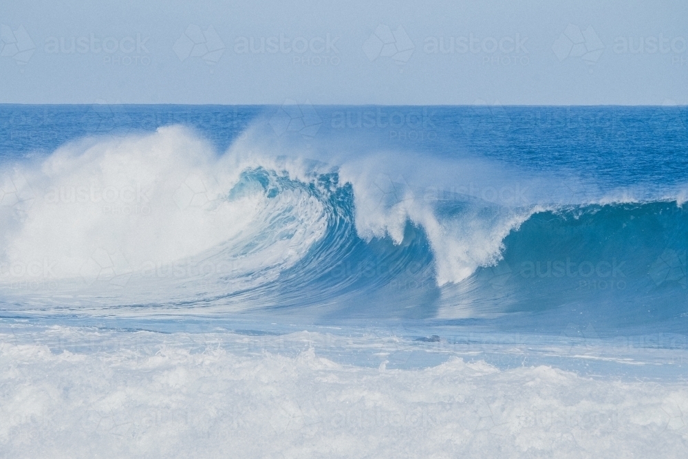 A big blue beautiful ocean wave crashing down - Australian Stock Image
