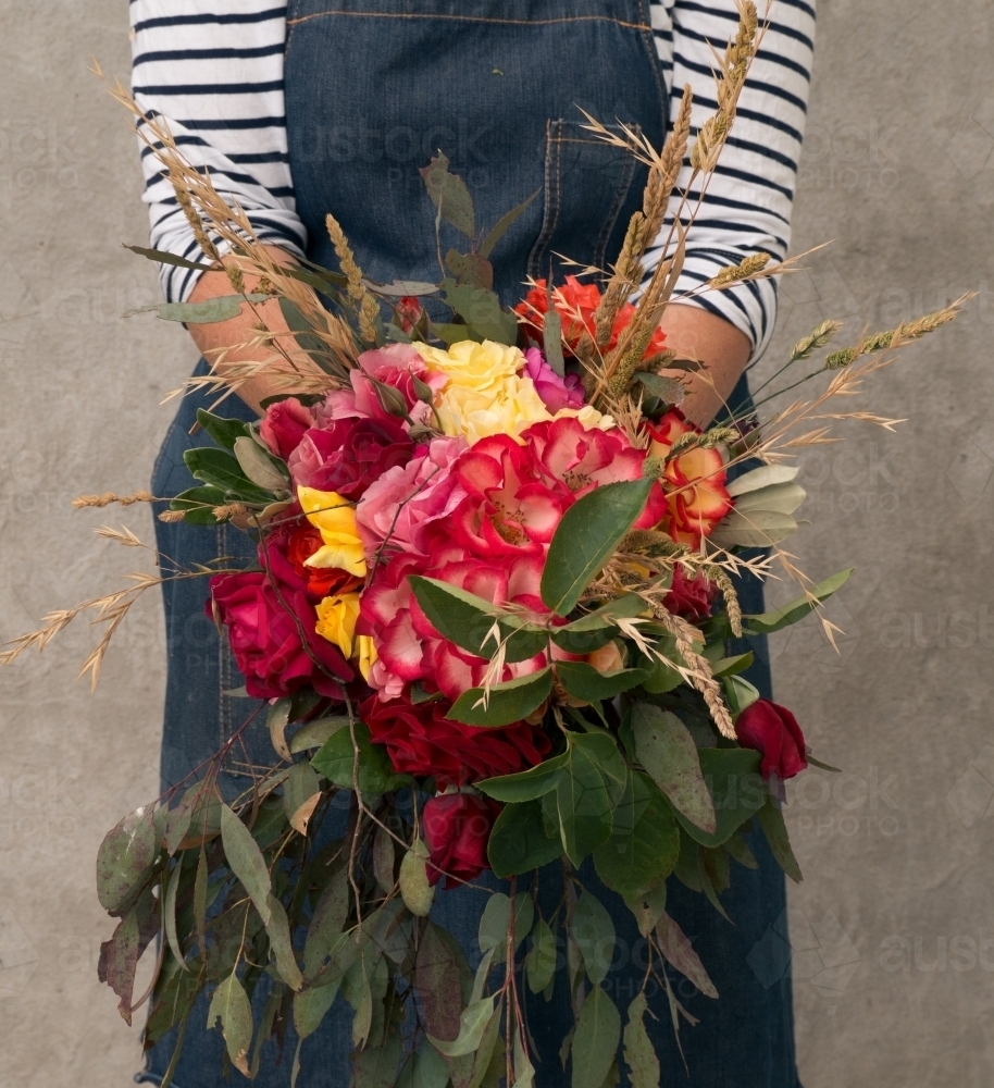 Image of A big bunch of bright roses with wild grasses and gumleaves ...