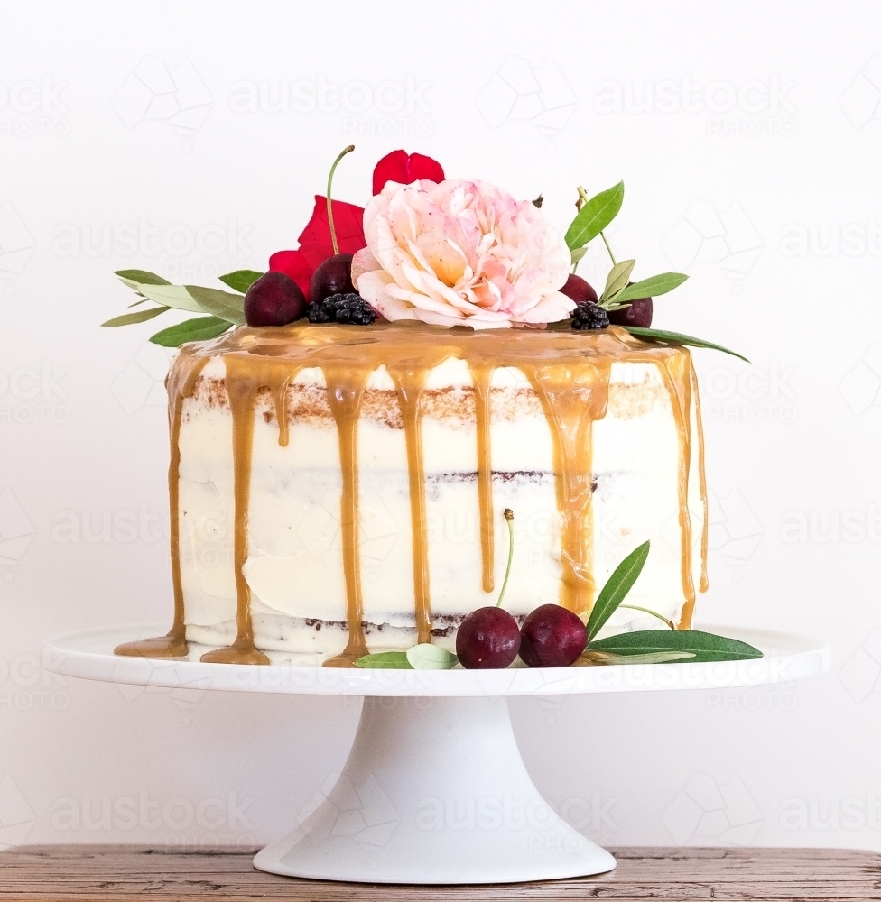 A birthday cake with flowers and fruit on a cake stand - Australian Stock Image