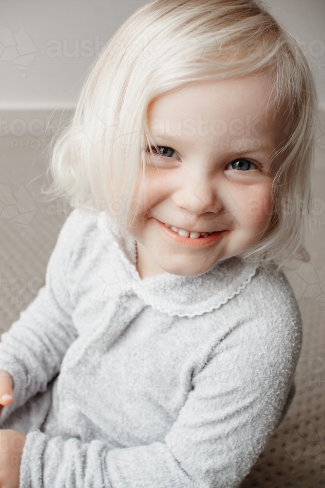 A blonde haired blue eyed two year old caucasian girl wearing a traditional Australian grow suit - Australian Stock Image