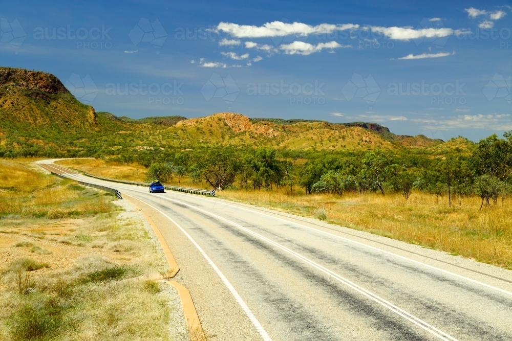 A blue ute driving on Great Northern Highway in the Kimberley region of Western Australia - Australian Stock Image