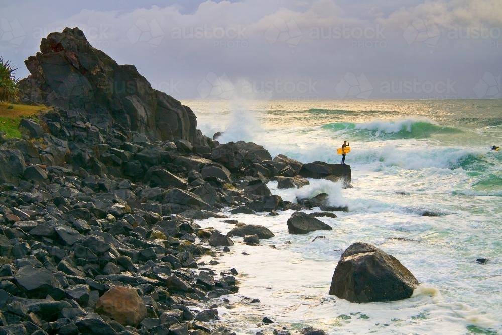 A boogieboard rider prepares to jump into the surf - Australian Stock Image