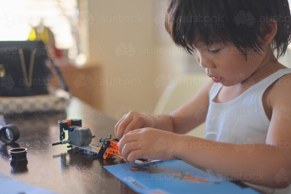 a boy, building a Lego formula race car - Australian Stock Image