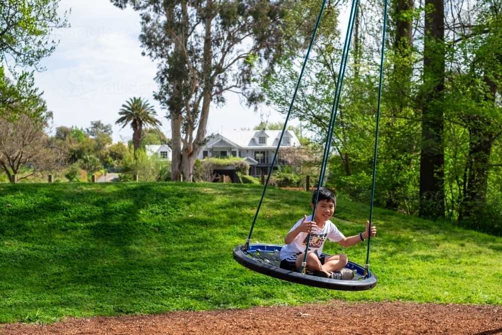 A boy enjoying a giant swing ride - Australian Stock Image