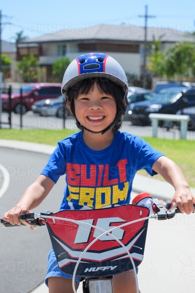 a boy happily riding his bike on a bike track - Australian Stock Image