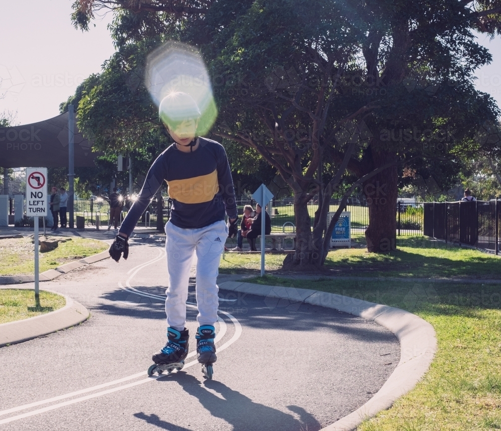a boy inline skating at the park with rollerblades - Australian Stock Image