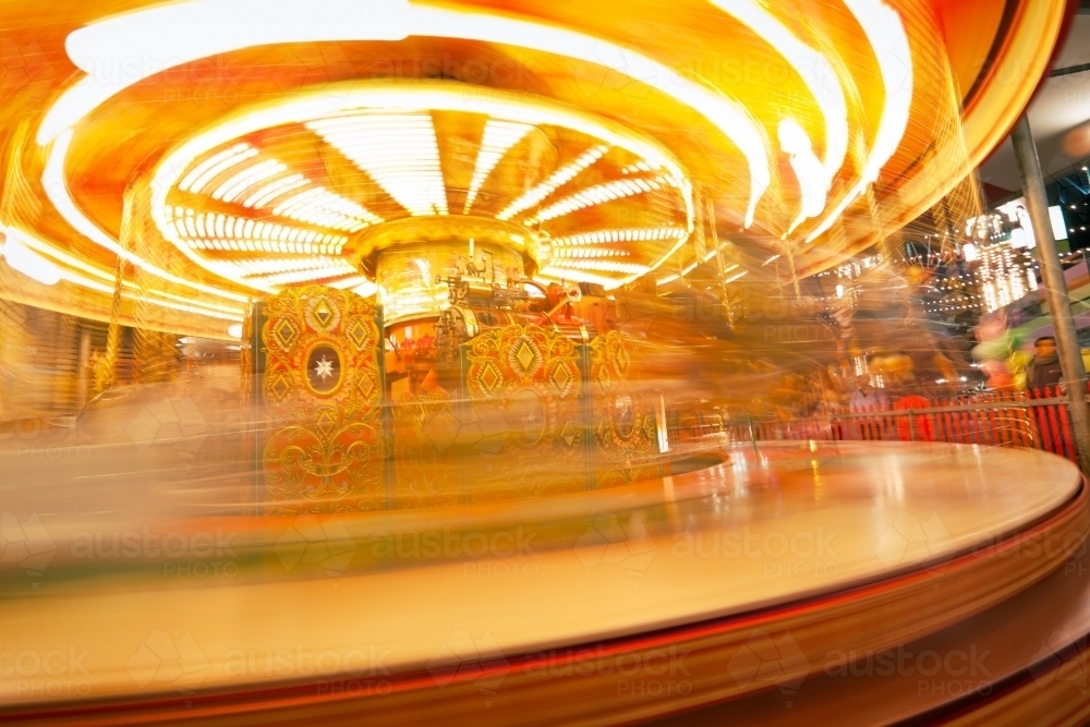 A brightly lit carousel spinning fast. - Australian Stock Image