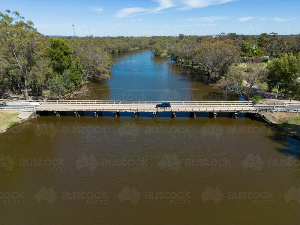 A car driving across a low bridge crossing of Lake Forbes - Australian Stock Image