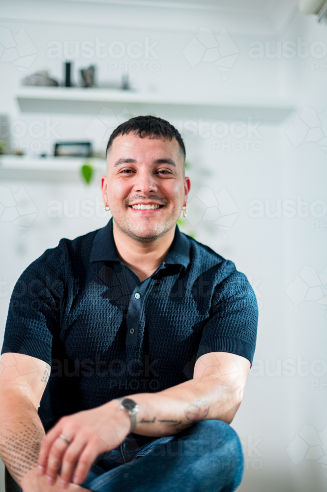 A cheerful man in his thirties poses casually indoors, showcasing a warm smile and relaxed vibe. - Australian Stock Image