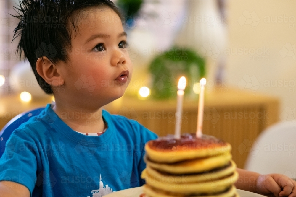 a child about to blow his birthday candles on a pancake stack - Australian Stock Image