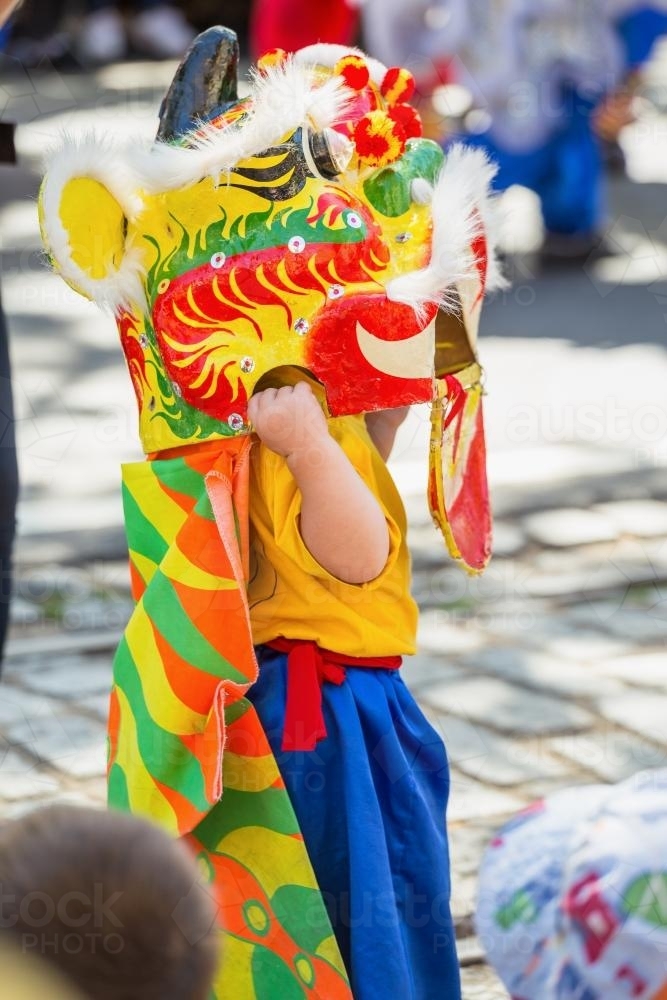 A child wearing a Chinese Dragon mask - Australian Stock Image