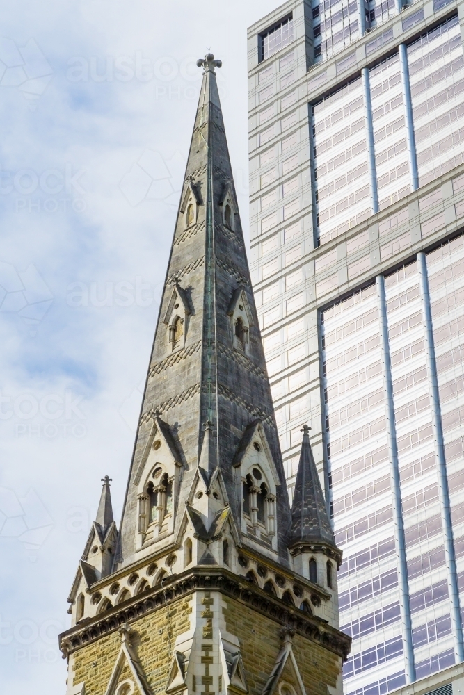 A church steeple rises next to a modern city skyscraper - Australian Stock Image