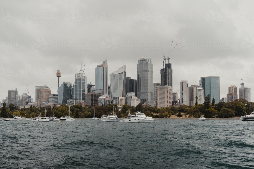 A cityscape of the Sydney on cloudy day with boats on the harbour. - Australian Stock Image