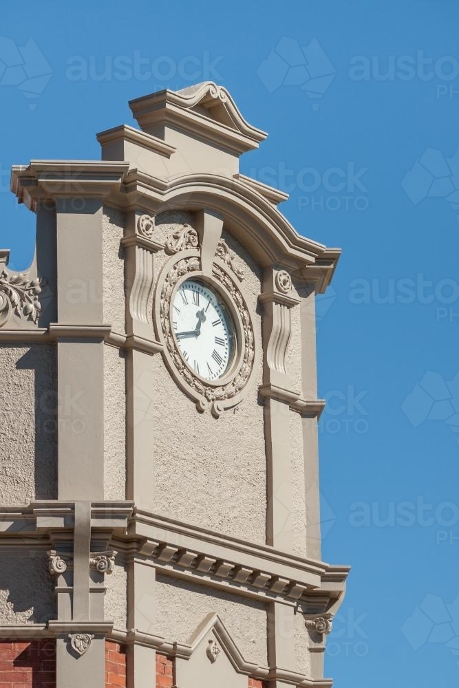 A clock face on the corner of a building facade - Australian Stock Image