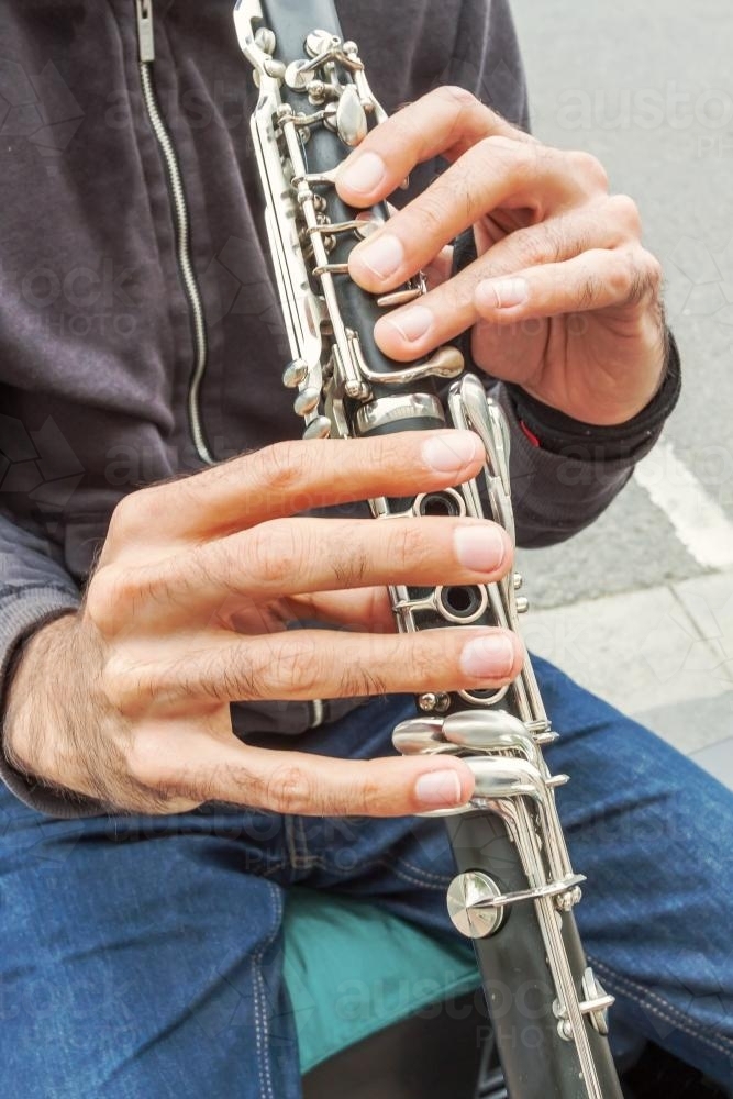 A close up of a a musicians hands playing a clarinet - Australian Stock Image