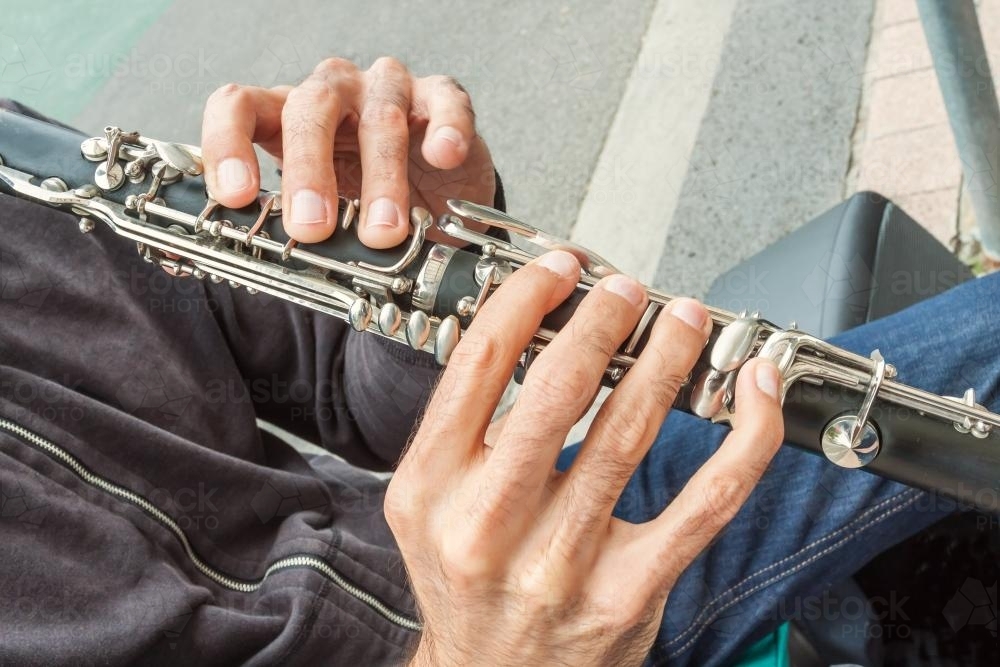 A close up of a musicians hands playing a clarinet - Australian Stock Image