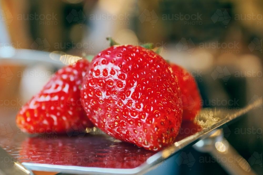 A close up of three glazed strawberries - Australian Stock Image