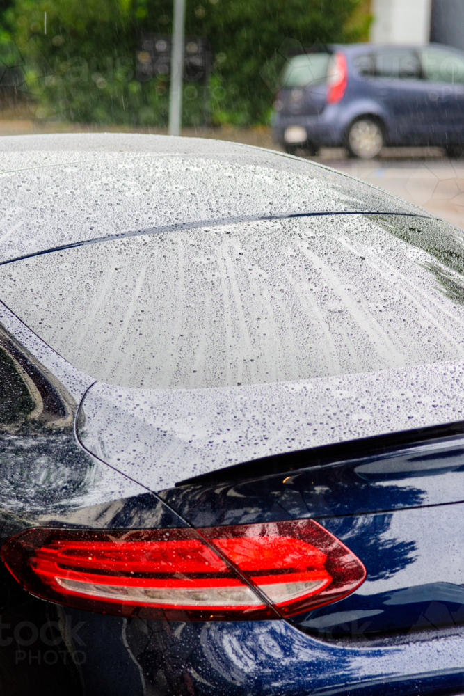 A Close up of Water Droplets on a Car's Back Window on a Rainy Day - Australian Stock Image