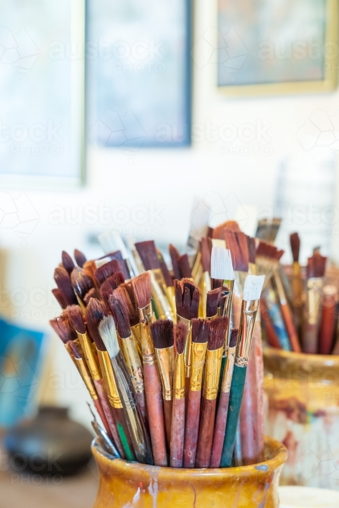 Image of A collection of artists paint brushes in a pottery jar