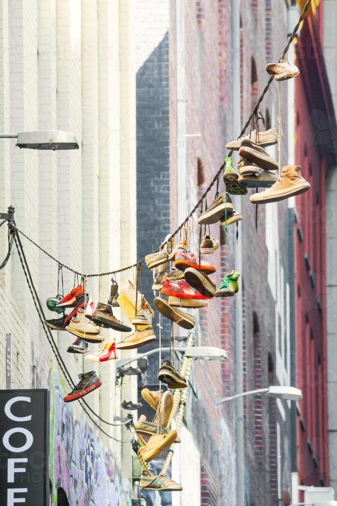 A collection of footwear hanging in a city laneway - Australian Stock Image