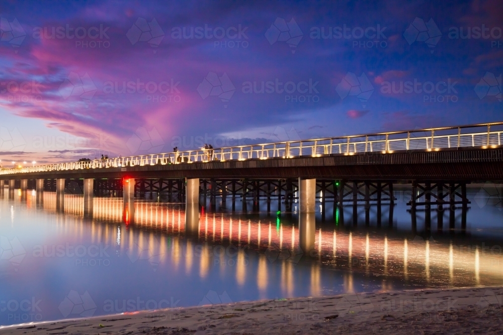 A coloured sunset sky and the lit up bridge over the Barwon River - Australian Stock Image