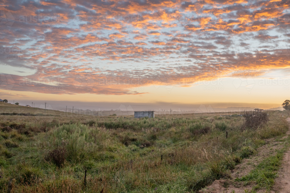 A colourful dawn sky over a country field - Australian Stock Image