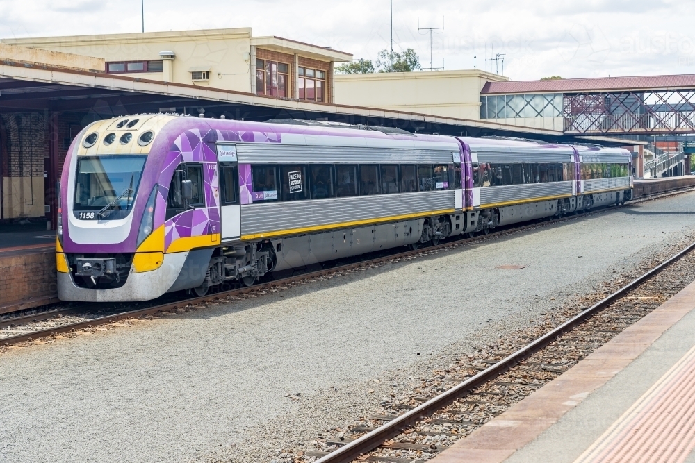 A commuter train waiting at a railway platform - Australian Stock Image