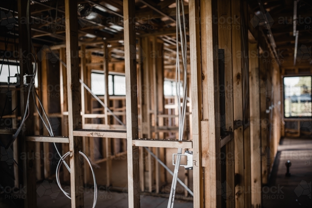 A construction site of a house being built with exposed wires and wooden beams - Australian Stock Image