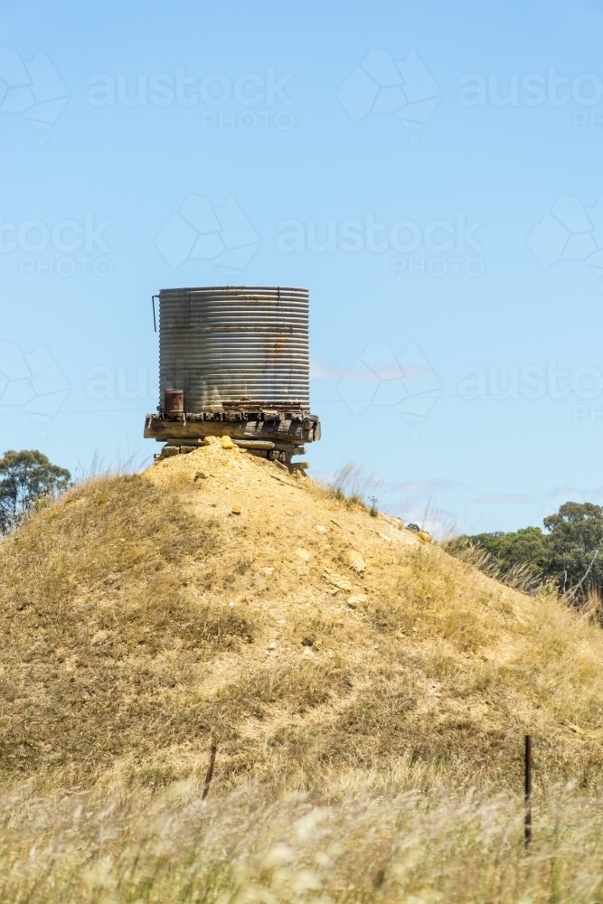 A corrugated iron tank sitting on a mound of gravel - Australian Stock Image