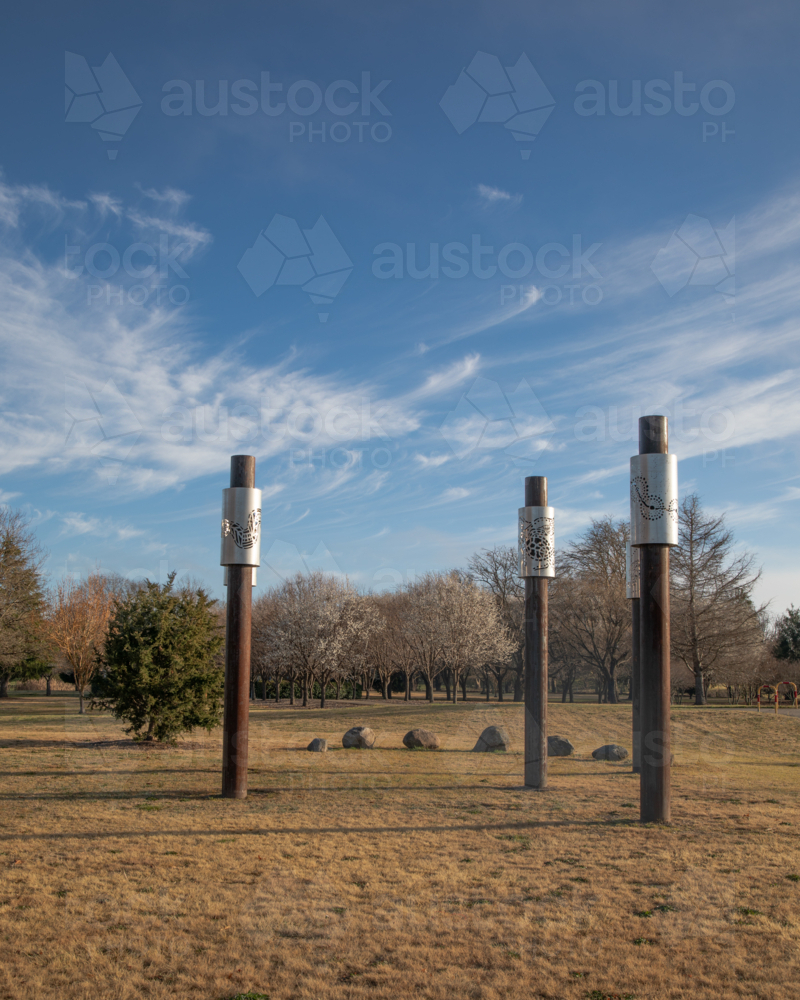 A country park with timber structures under a blue sky with wispy clouds - Australian Stock Image