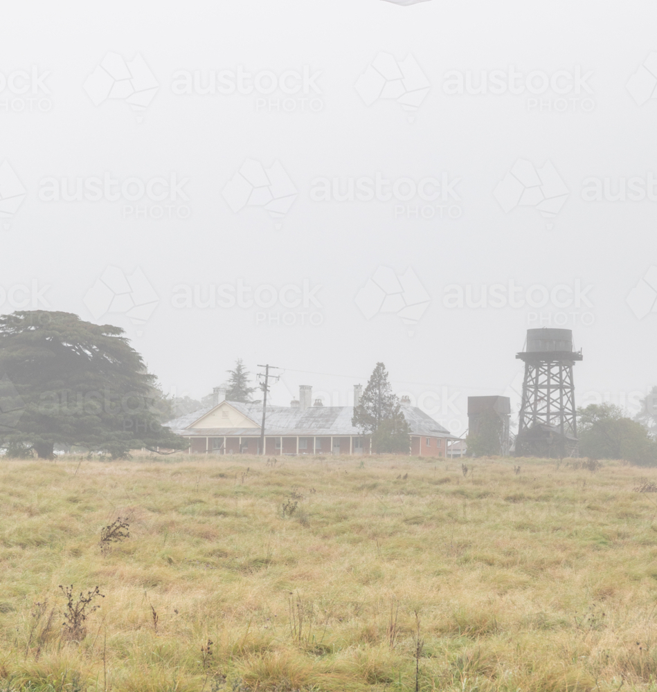A country scene with an old homestead and a water tank - Australian Stock Image
