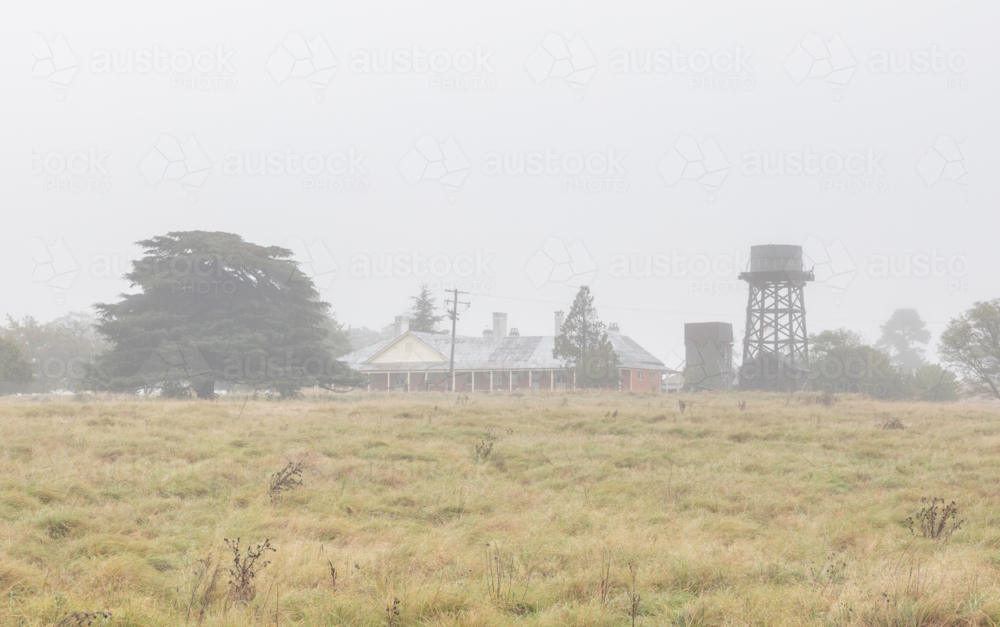 A country scene with an old homestead and a water tank - Australian Stock Image
