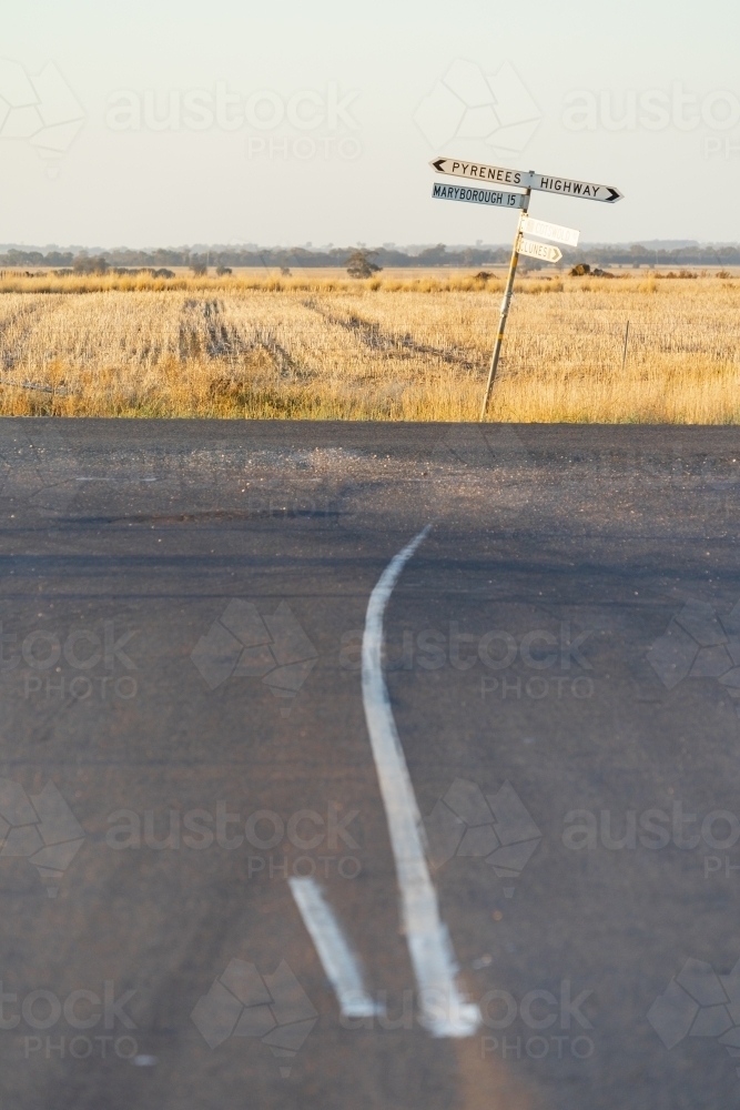 A crooked signpost on a roadside of a rural intersection - Australian Stock Image