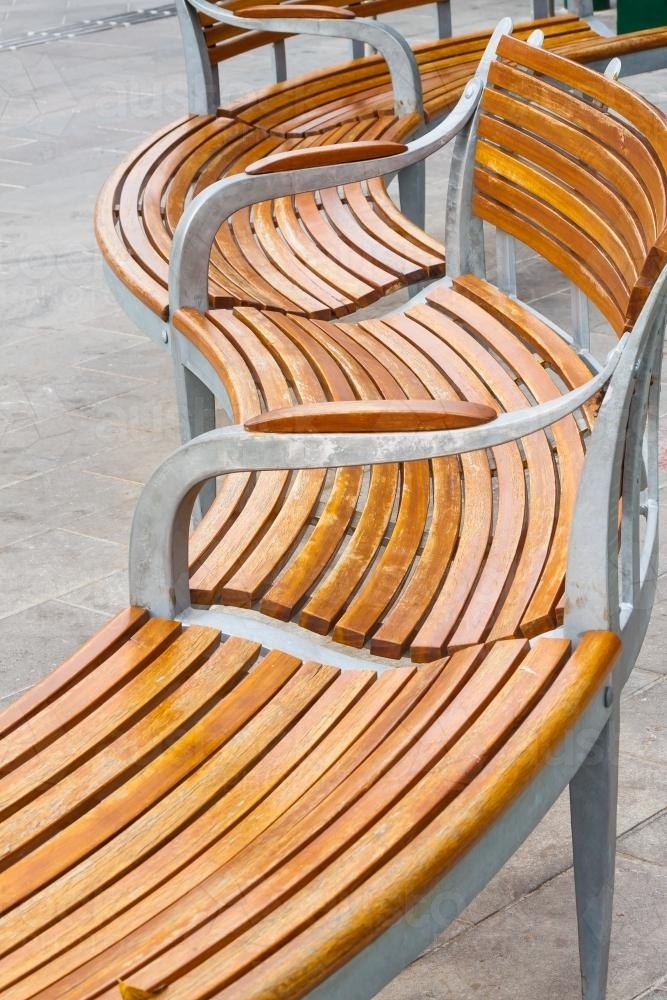 Image of A curved wooden park bench in detail Austockphoto