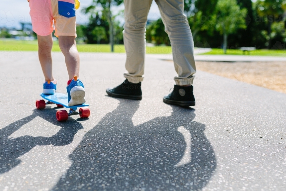 Dad teaching his son how to ride a skateboard - Australian Stock Image