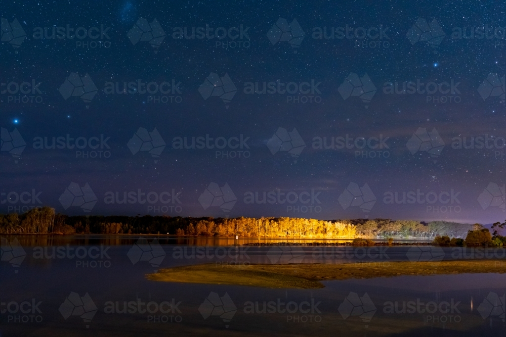 A dark starry night sky over a coastal inlet and mangroves - Australian Stock Image